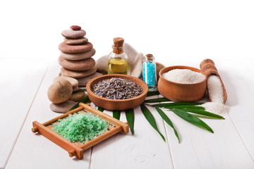 Spa stones with lavender flowers and sea salt on a white wooden background.