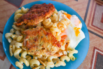 Breakfast. Dinner. Pasta with fried eggs. Fried chop.