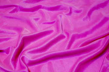 Texture, abstract background, silk pink fabric artistically laid out.