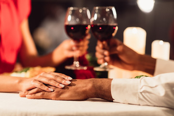 Unrecognizable Black Couple Holding Hands And Clinking Glasses In Restaurant