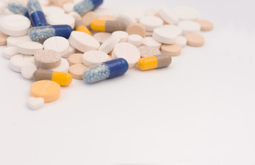 Heap of colorful pills in the shape of a heart, tablets and capsules on white background. Drug...