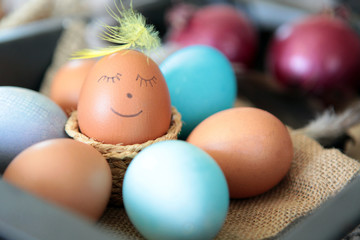 Colorful Easter eggs with smiling emoticon for handpaintings at home. brown eggs face arranged together on the paper background, Selective focus at the eeg. Many colorful organic chicen fresh eggs