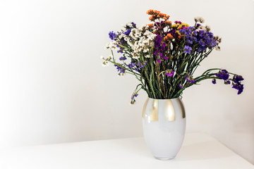 bouquet of flowers on the white table, cozy home interior.