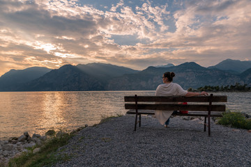 Sonnenuntergang am Gardasee mit Frau auf Bank