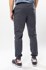 Fototapeta na wymiar athletic man in sweatpants and sneakers on a white background, men's sports pants close-up