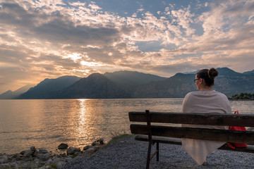 Sonnenuntergang am Gardasee mit Frau auf Bank