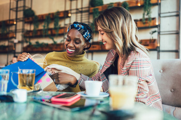 Two female friends talking at a coffee shop, after shopping.