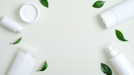 Frame of organic cosmetic bottle containers and green leaves. Minimalist cosmetic product mockups,...