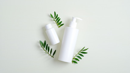 Clear cosmetic bottle containers and green leaves. Minimalist cosmetic product mockups. Natural...