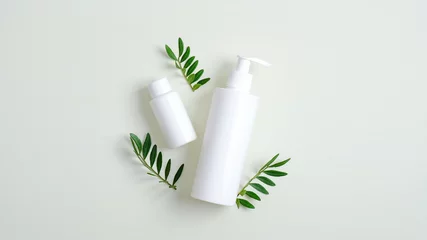 Poster Clear cosmetic bottle containers and green leaves. Minimalist cosmetic product mockups. Natural hand care cream and lotion packaging, beauty SPA cosmetic branding concept © photoguns