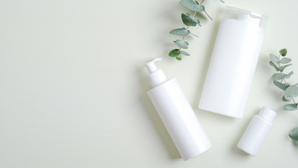 Natural organic cosmetic bottle containers and eucalyptus green leaves. Minimalist cosmetic product mockups, natural branding. Organic beauty cosmetics for SPA treatment