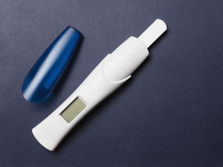 Blank electronic pregnancy test on blue background, with open cover, ready for testing, with LCD screen. Copy space, top view