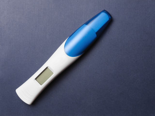 Blank electronic pregnancy test on blue background, with LCD screen. Copy space, top view