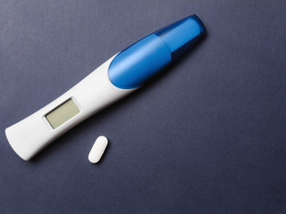Concept, medical termination of pregnancy at an early stage. Blank electronic pregnancy test on blue background, with LCD screen. Copy space, top view