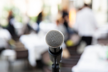 Microphone on blurred of speech in seminar room or speaking conference