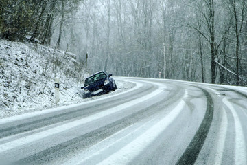 Abandoned car in the ditch the traffic accident during a snow fall. Symbolises bad weather...