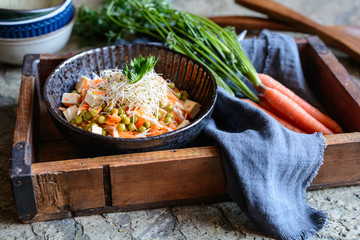 Easy vegan salad with boiled green peas, fresh parsley root slices and carrot, smoked tofu and topped with Alfalfa sprouts