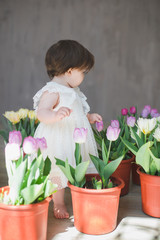 Beautiful smiling baby girl among the tulips.