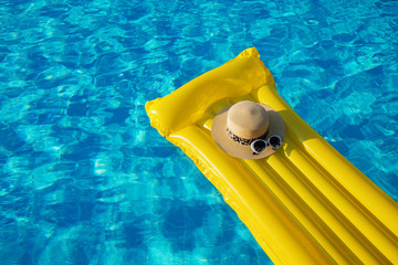 Beach summer holiday background. Inflatable air mattress, hat on swimming pool.