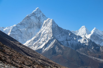 Ama Dablam mountain peak in Himalayas in sunny day. It's a mountain in the Khumbu region of the Nepalese Himalaya. Route to Everest base camp in Sagarmatha national park.