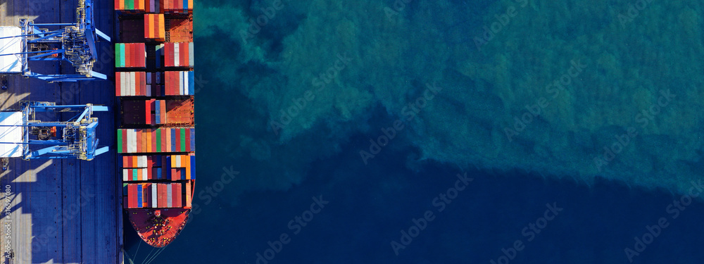 Sticker aerial drone ultra wide top down photo of commercial container terminal with cranes loading shipment