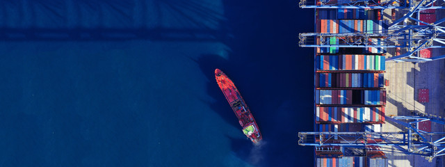 Aerial drone ultra wide top down photo of commercial container terminal with cranes loading...