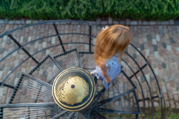 woman walking down a spiral staircase