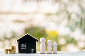 Family and blackboard house model and stacked gold coin with growing put on the wood in the garden, Loan for business investment real estate or saving money for buy home to one's love concept.