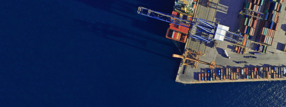 Aerial drone ultra wide top down photo of commercial container terminal with cranes loading shipment to tanker ships in Mediterranean port - Powered by Adobe