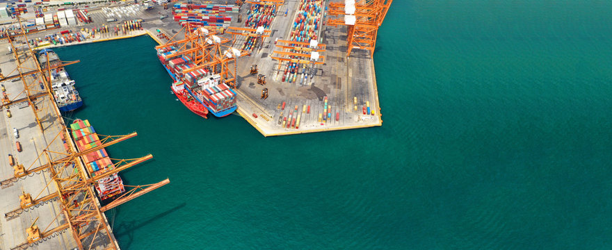 Aerial drone ultra wide top down photo of commercial container terminal with cranes loading shipment to tanker ships in Mediterranean port