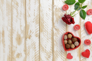 Valentines day romantic decoration with roses and chocolate on a white wooden table. Top view, copy space.