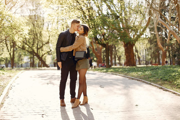 Cute couple in a park. Lady in a brown jacket.