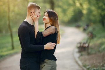 Cute couple in a park. Lady in a black blouse