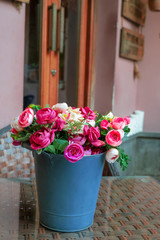 Fototapeta na wymiar colorful roses in a bucket on the table