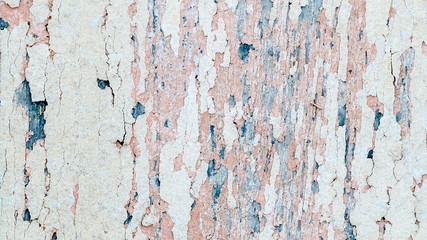 Flaking pink-blue paint on a faded wooden background