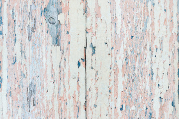 Flaking pink-blue paint on a faded wooden background
