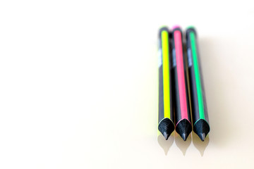 Sharpened rods of multi-colored pencils on a light surface