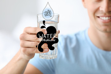 Man with glass of water, closeup. Problem of pollution