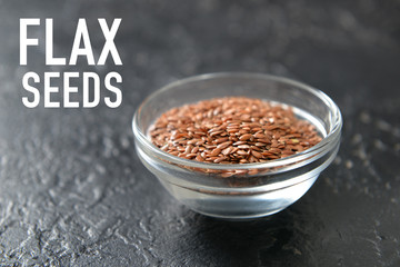 Bowl with flax seeds on dark background