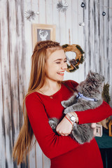 Cute little girl playing with gray cat. Lady in a studio