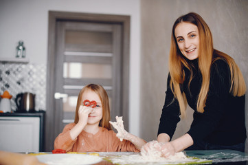 Family in a kitchen. Little girl with a dough.