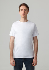 man in white t-shirt and dark jeans isolated on studio background
