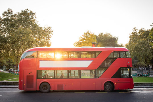 Red Double Decker Bus Of London Parked Near The Park By Sunset