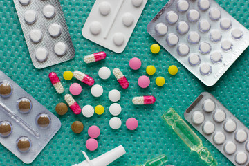 Multi-colored pills and a bottle with medicine on the table