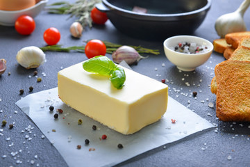 Fresh butter with bread and spices on dark background
