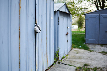 Old metal doors are closed on a padlock.