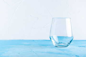empty glass with on a white concrete background on a blue table