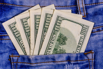 American one hundred dollar banknotes in a pocket of blue jeans