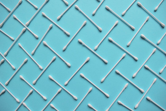 Cotton buds and sponges on blue background. Plastic cotton swabs. Top view ear sticks. Flat lay composition products for remove cosmetics.