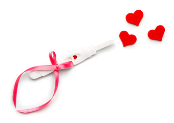 Pregnancy test and hearts on white background